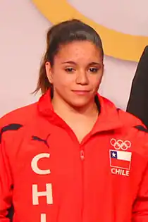 a woman wearing a red shirt with the Olympic rings and the Chilean flag