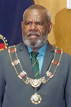 Bob Dadae in a suit wearing a chain of office
