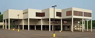 Southdale Library, a modern-style white building in an inverted step sequence supported by pillars over its parking lot on a sunny day