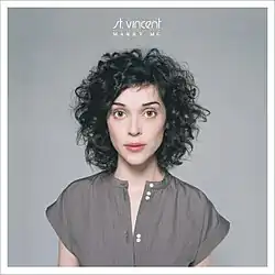 Profile image of St. Vincent in a gray button-up shirt against a lighter gray background