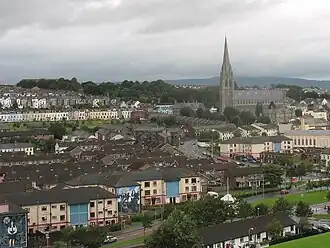 A view of Derry looking towards St Eugene's Cathedral, the mother church of the Roman Catholic diocese of Derry, across the Bogside's Lecky Road and Fahan Street, taken from the Grand Parade on the City Walls. Houses are visible, two have a mural