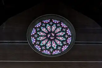The large western Rose Window, with tracery designed by William Henry Skinner, glazed with cathedral glass, was the only stained glass installed during construction, 1895.