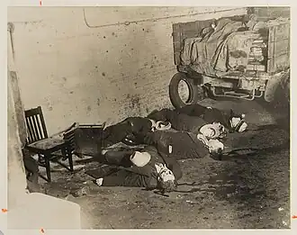 Six men lying dead on the floor; their blood is clearly visible on the floor