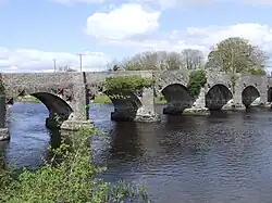 a stone bridge viewed from the bank