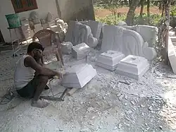 A man carves stone with an electric tool