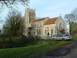 A stone church seen from the southeast with stepped gables, also showing the south chapel, porch, clerestory, and decorated tower