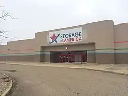 A former Target department store made of gray brick, repurposed as a storage unit. Present is signage reading "Storage of America"