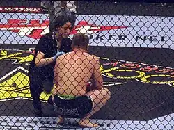 Image 15A ring-side doctor attends to a fighter following a loss. (from Mixed martial arts)