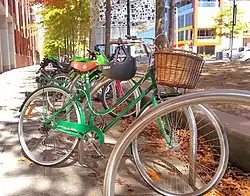 A step through ladies bicycle and other bikes parked on the street.
