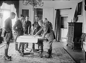 Photograph of a group of officers looking at plans on a table