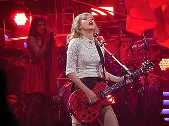 Swift playing a red electric guitar