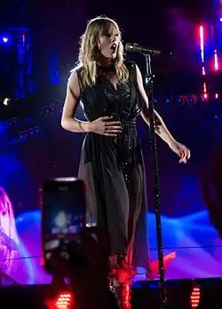 Taylor Swift performing while dressed in a black gown