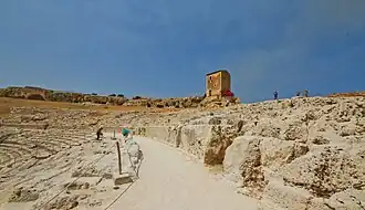 The final steps of the Greek theatre, the Casetta dei mugnai and the cavity of the Grotta del Ninfeo in the distance