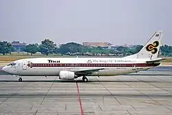 A Boeing 737 labelled "Thai" with a purple cheatline