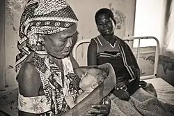 A happy grandmother holds a new baby after a successful delivery at the health post in Mandimba, Niassa Province, Mozambique