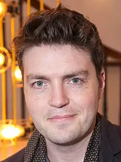 A photograph of Tom Burke