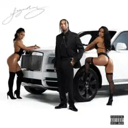 Tyga in a black suit, standing in front of a white luxury car, posing with two scantily-clad women