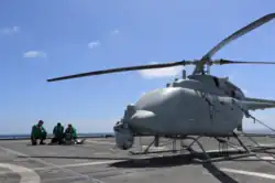 U.S. Navy sailors with an unmanned helicopter on the flight deck of a U.S. Navy ship.