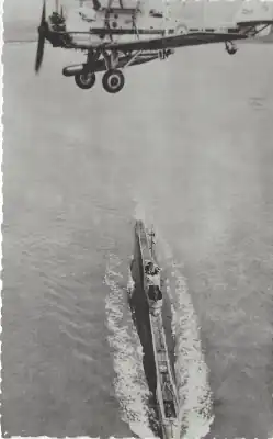 Picture of a plane flying over a submarine.