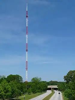 An antenna tower 1,075 feet (328 m) tall in Atlanta, GA with its red and white aircraft warning paint visible.