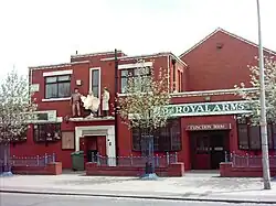 Red brick building by roadside with life size figures of John Wayne, Marilyn Monroe and Humphrey Bogart and on high above doorway