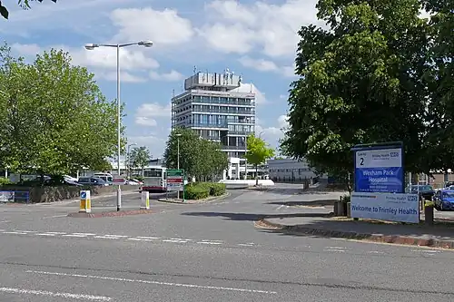 A hospital car park with a squat tower in the background