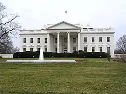 A north side view of the White House, showing the main building and the water feature in front of it