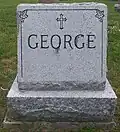 Grey granite stone engraved with the George family name and adorned with a cross