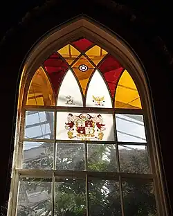 Stained glass window at Aberglasney House. The ninfarium glasshouse can be seen behind it