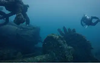 A diver swims near a shipwreck.