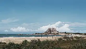 Sandy beach with a rocky outcrop in sea side