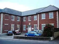 red brick building with small car park in front.